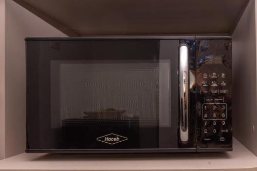 a black microwave oven sitting on top of a counter at confortable apartasuite en la playa in Gaira