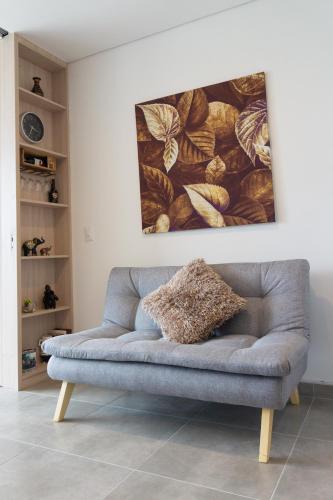 a couch in a living room with a painting on the wall at confortable apartasuite en la playa in Gaira