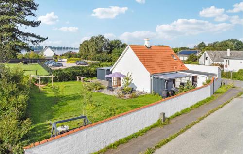 a white house with an orange roof and a yard at Stunning Home In Askeby With Kitchen in Askeby