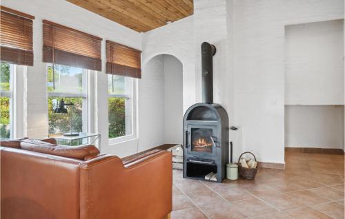 a living room with a fireplace and a couch at Stunning Home In Askeby With Kitchen in Askeby