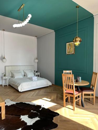 a bedroom with a bed and a table and chairs at Oyster Flat Victoriei in Bucharest