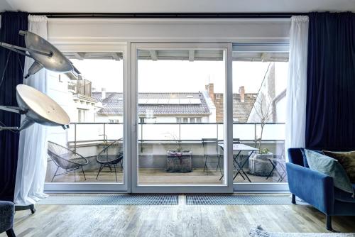 a living room with a large window with a view of a table at Gorki Apartments in Berlin