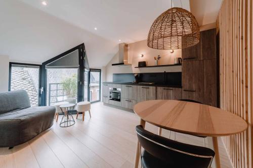 a living room with a table and a couch at Chimay : La Chambre Dorée de la Grand Place in Chimay