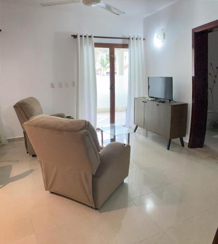 a living room with a chair and a television at OKAINA 2 in Cabarete