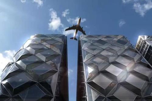 an airplane flying in the sky above two buildings at Newly refurbished flat,Marble floors.Central Cairo in Cairo