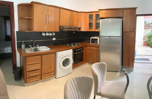 eine Küche mit Holzschränken und einem Kühlschrank aus Edelstahl in der Unterkunft OKAINA 2 in Cabarete