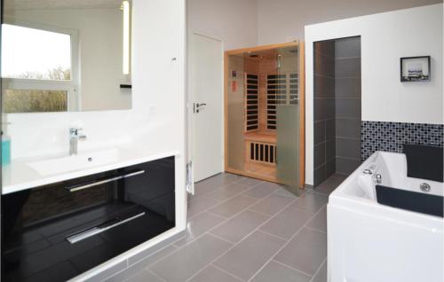 a bathroom with a sink and a mirror and a shower at Amazing Home In Hvide Sande With 5 Bedrooms, Sauna And Wifi in Hvide Sande