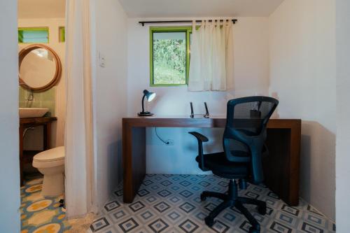 Habitación con baño con escritorio y silla. en La Cabaña - Monte Jazmín, en Pereira