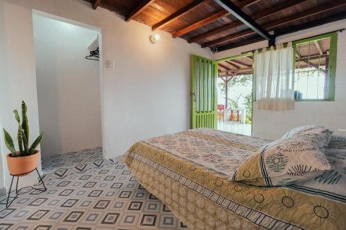 sypialnia z łóżkiem i doniczką w obiekcie La Cabaña - Monte Jazmín w mieście Pereira