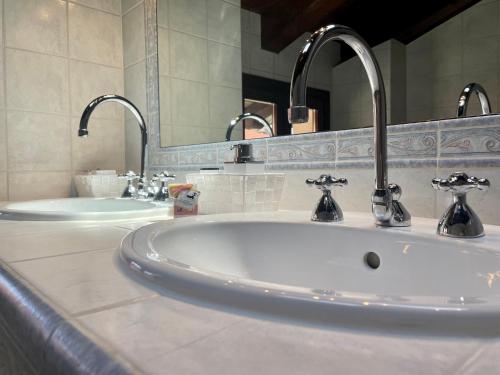 a bathroom with two sinks and two faucets at StaraGo Attic Suite - Elegante mansarda in centro storico in Gorizia