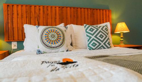 a bedroom with a bed with pillows and a bed sidx sidx at Pouso da Rita - Tiradentes in Tiradentes