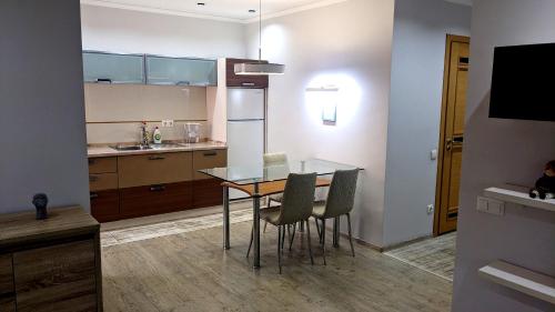 une cuisine avec une table et des chaises dans une pièce dans l'établissement Damaris Apartments, à Chişinău