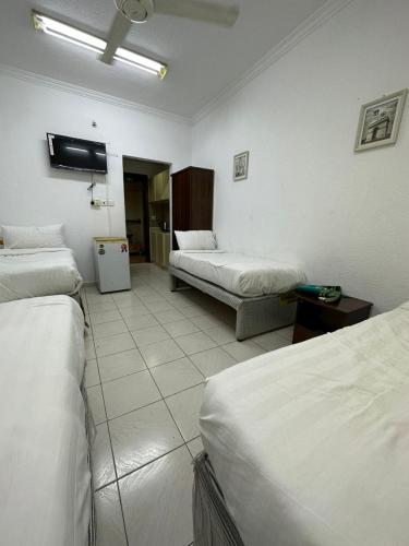 a hotel room with two beds and a tv at فندق النجمتين الفضية in An Naqāʼ