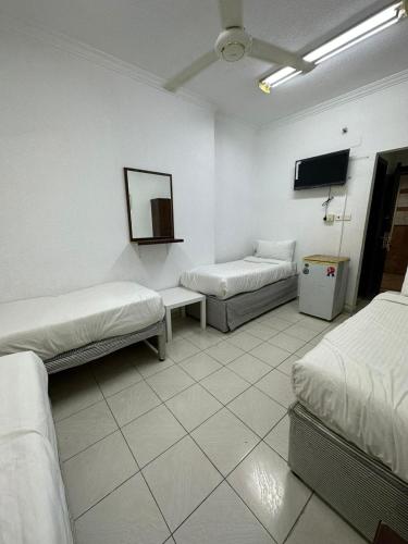 a room with two beds and a flat screen tv at فندق النجمتين الفضية in An Naqāʼ
