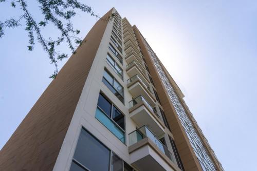 an apartment building with a tall building at confortable apartasuite en la playa in Gaira