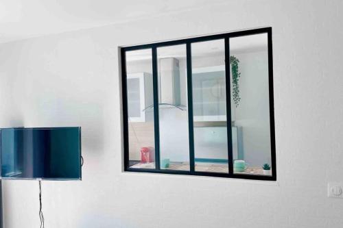 ein Spiegel hängt an einer Wand neben einem Fenster in der Unterkunft Chic And Cosy Studio proche ParisAéroport CDG in Villepinte