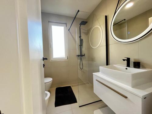 La salle de bains blanche est pourvue d'un lavabo et d'un miroir. dans l'établissement Brand new, 1 bedroom apartment Poreč, à Poreč