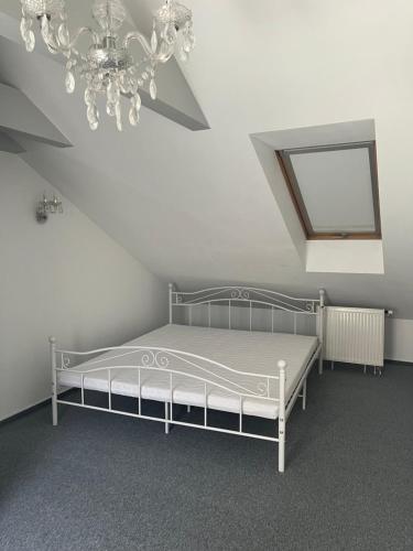 a bedroom with a white bed and a chandelier at Apartament Wiedeński in Bielsko-Biała