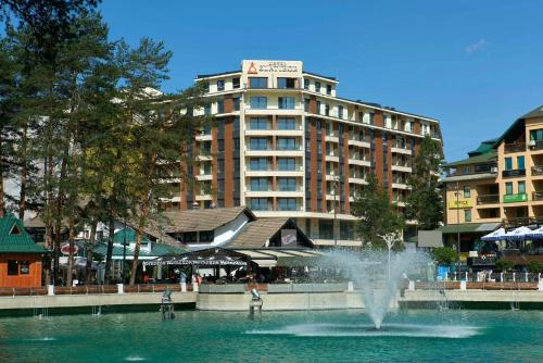 a fountain in the water in front of a building at King's Square Lux apartment Zlatibor 1 in Zlatibor