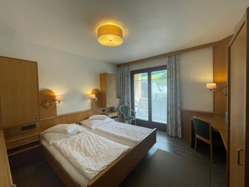 1 Schlafzimmer mit 2 Betten und einem Fenster in der Unterkunft Restaurant-Pension Dorfwirt in Bad Kleinkirchheim
