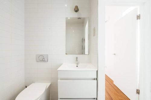 a white bathroom with a sink and a mirror at Modern 1BD Flat -Stoke Newington in London