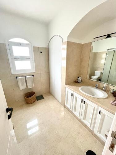 a bathroom with a sink and a mirror at BEAUTIFUL 4-BEDROOM VILLA WITH POOL AND VIEWS OF THE LAGOON AND GOLF COURSE in Hurghada