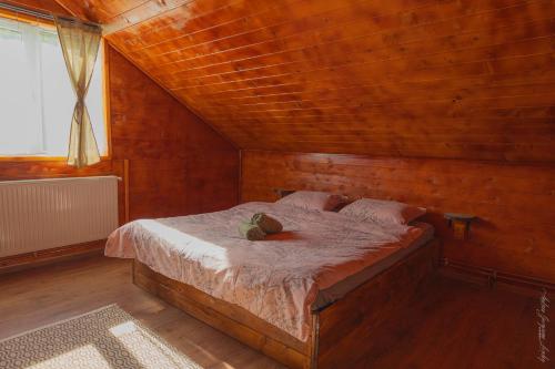a bedroom with a bed in a wooden room at Cabana Amis in Poeni
