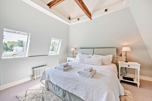 a bedroom with a white bed with towels on it at Bedgebury Oast by Bloom Stays in Goudhurst