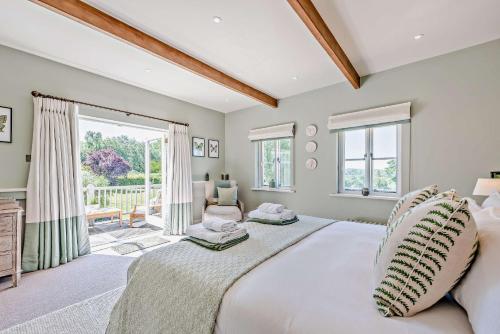 a bedroom with a large bed and a large window at Bedgebury Oast by Bloom Stays in Goudhurst