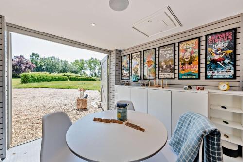 a kitchen with a white table and chairs and a window at Bedgebury Oast by Bloom Stays in Goudhurst