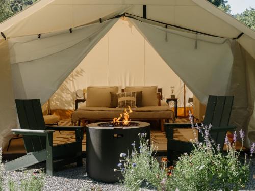 a tent with a couch and a fire pit in a yard at Dawn Ranch in Guerneville