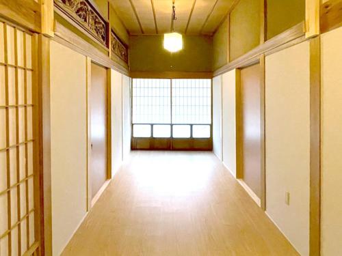 an empty hallway with a large window in a building at Yananose house in Dekiji