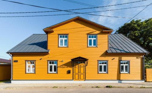 a yellow house with a black roof at Posti Guesthouse in Rakvere