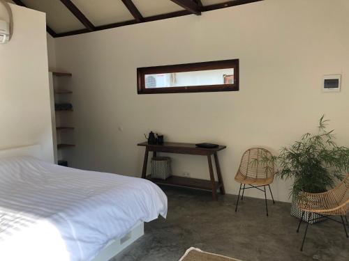 Schlafzimmer mit einem Bett, einem Schreibtisch und einem Stuhl in der Unterkunft OUTSIDE bungalow in Sekongkang