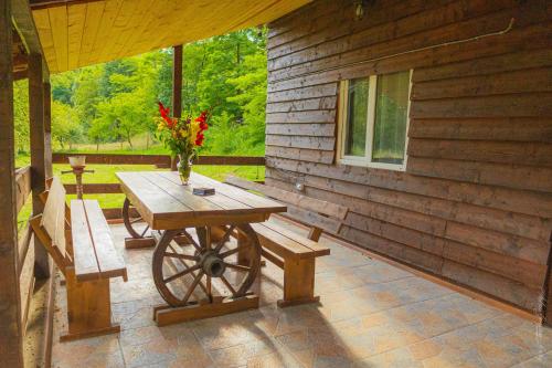a wooden table and bench on a porch of a cabin at Cabana Amis in Poeni