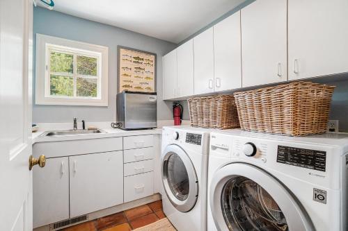 a white laundry room with a washer and dryer at Blue Bear in Glen Arbor