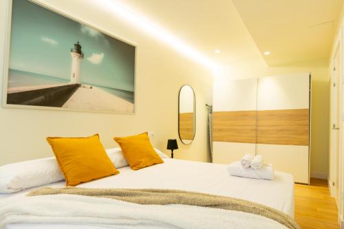 a bedroom with a bed with yellow pillows and a lighthouse at BILBAO NORTH SHORE APARTMENTS 6 in Bilbao