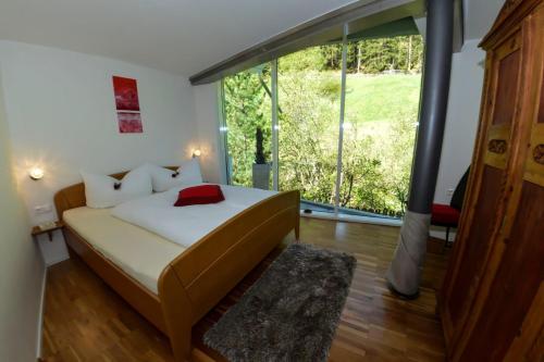 a bedroom with a bed and a large window at AlpinDesign Kaunertal in Kaunertal