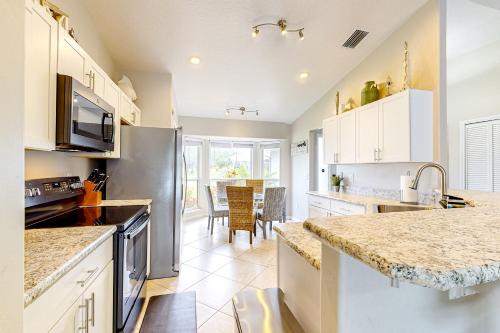 a kitchen with white cabinets and granite counter tops at Serene Sebastian Escape in Sebastian