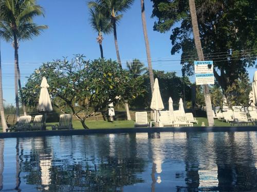 basen z krzesłami i palmami w obiekcie Casa Paradise Fiore w mieście Paripueira