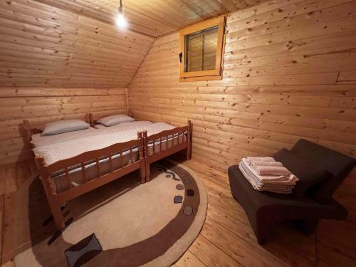 een slaapkamer met een bed in een blokhut bij Vikendica Green Forest, Zenica in Zenica