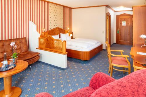 a hotel room with a bed and a couch at Parkhotel an der Therme in Bad Krozingen