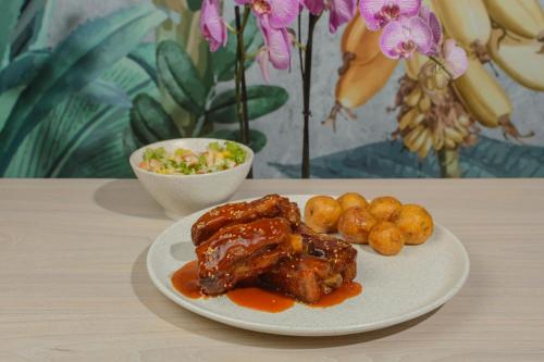 a plate of food with meat and potatoes on a table at Hotel Anamela in Maní