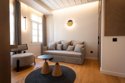 a living room with a couch and two tables at Navria by Aetoma in Nafplio