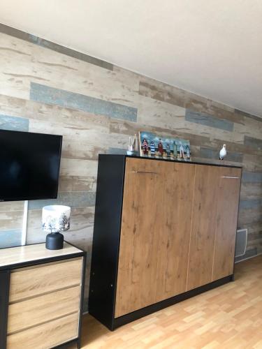 Cette chambre est dotée d'un mur en bois et d'une grande porte en bois. dans l'établissement Studio Bords de plage, à Saint-Jean-de-Monts