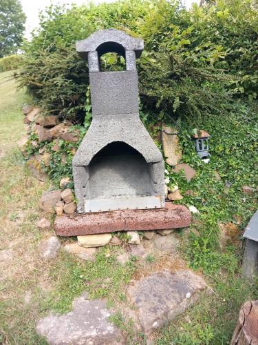 an outdoor oven sitting on top of a stone wall at Au tonneau bleu in Lembach