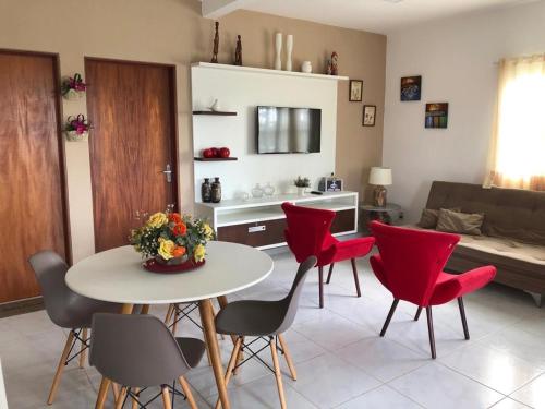 a living room with a table and red chairs at Casa Paradise Fiore in Paripueira