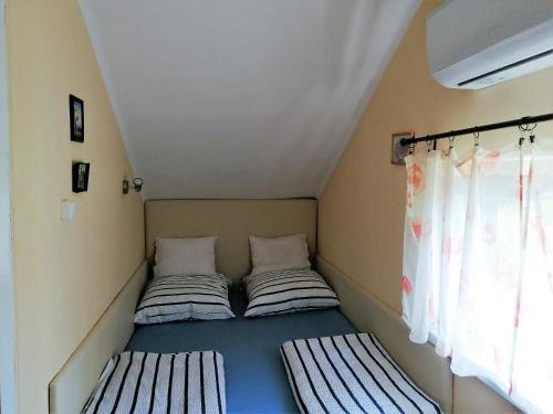 two beds in a small room with a window at Oázis Vendégház in Gyula