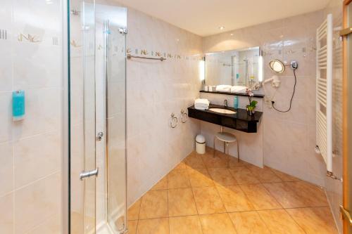 a bathroom with a shower and a sink at Parkhotel an der Therme in Bad Krozingen