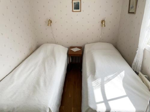- 2 lits dans une petite chambre avec une table dans l'établissement Cozy cottage close to Farjestaden, à Färjestaden